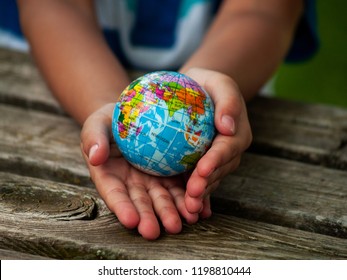 A boy with a ball of the world or planet Earth in his hands. Ecology concept - Powered by Shutterstock