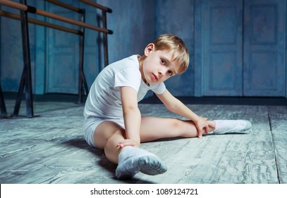 boy ballet dancer doing exercise and stretching at  dance class near the barre indoors