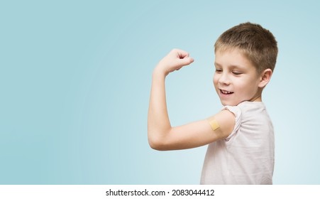 Boy with bandage plaster on his arm makes fist and flexes her bicep after vaccination. Injection covid vaccine, healthcare for children. Banner, copy space. - Powered by Shutterstock