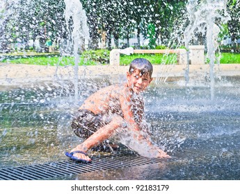 The Boy Is Bathed In The Fountain. Summer Hot Weather