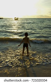 Boy in the beach at sunset.
