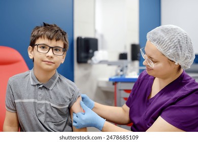 A boy is being vaccinated. A child is given a vaccine during an epidemic or outbreak of a disease. A kid during routine vaccination - Powered by Shutterstock