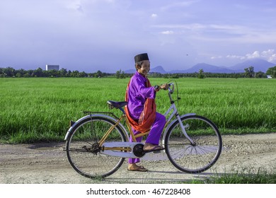 Boy With Bicycles At Paddy Field At Parit Penghulu, Sungai Rambai, Melaka During Blue Sky