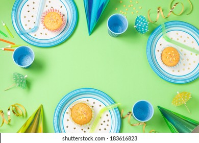 Boy Birthday Green Table Setting From Above With Muffins, Drinks And Party Gadgets. Background Layout With Free Text Space.