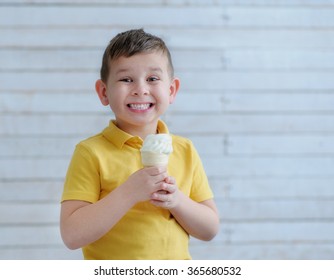 The boy bite into ice cream and smiling broadly at the camera