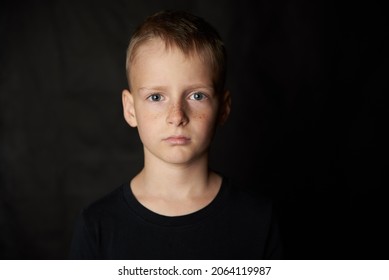 Boy Blond 10 Years Old On A Black Background