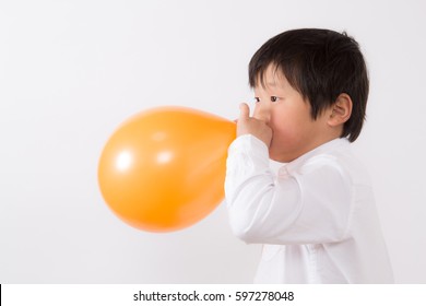 boy blowing up a balloon