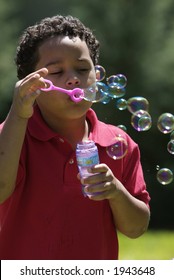 Boy blowing bubbles at the park
