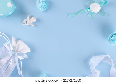 Its A Boy, Blue Theme Baby Shower Or Nursery Border Background On Pastel Blue Background. Flat Lay Layout With Baby Boy Clothes, Ceramic Nipple Or Baby's Dummy, Gift Box For Baby Shower Invitation