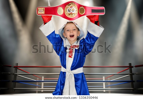 Boy boxer holding championship belt in\
Boxing.	\
Little champion.The big\
wins.\
