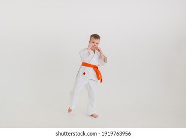 a boy boxer in a white kimono with an orange belt on a white background with a place for text