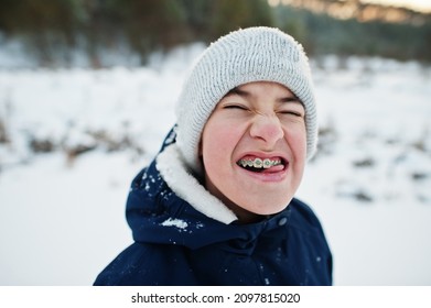 Boy With Braces Show Funny Face In Winter Nature. Outdoors In Snow.