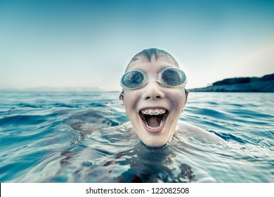 Boy with braces swimming and laughing