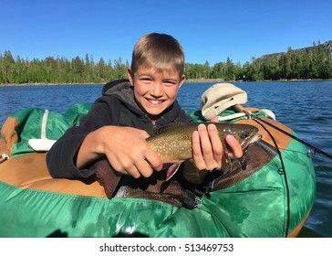 Boy With A Brook Trout Caught Fly Fishing On A Lake In The Wilderness 