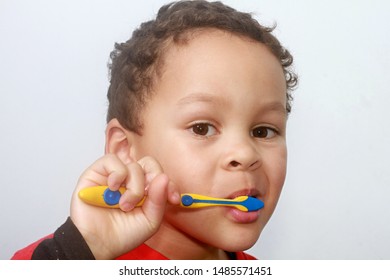 boy brushing his teeth with an electric tooth brush with grey background stock image stock photo