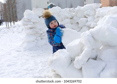 Boy building snow fortress at winter playground - Powered by Shutterstock