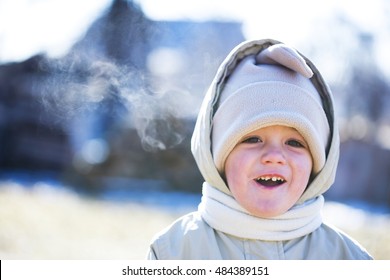 A Boy Bundled Up In Warm Winter Clothes In The Cold.