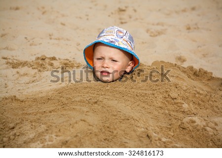 Similar – Image, Stock Photo Small child buried in the sand of the beach