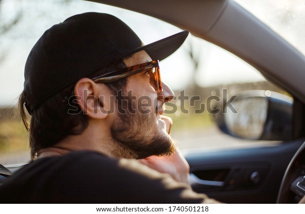 Boy in the car\
with the phone in his\
hands.