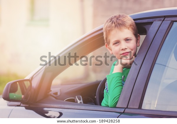Boy in a car\
smiling