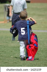 Boy Carrying Baseball Equipment Walking To Dad