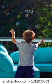 Boy chasing after vivid bubbles