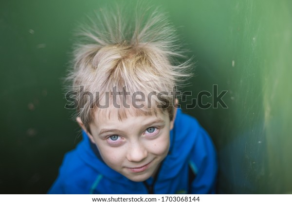 A boy in\
a chest with spiky hair due to\
electrify