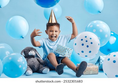 Boy, child and balloons for birthday party in studio portrait with present, happy or bunny doll by blue background. Kid, boxes and gift with toys, excited or celebration for milestone in Costa Rica - Powered by Shutterstock