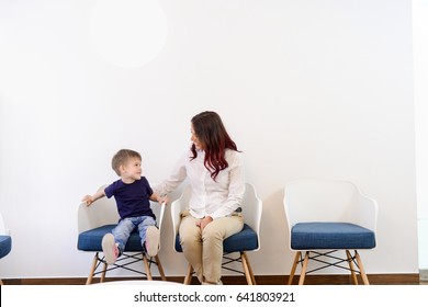 A Boy Child In Doctors Waiting Room - Reception With His Mom. Kids First Visit For A Regular Dentist Exam 