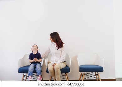 A Boy, Child In Doctors Waiting Room - Reception With His Mom. Kids First Visit For A Regular Dentist Exam