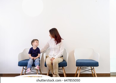 A boy child in doctors waiting room - reception with his mom. Kids first visit for a regular dentist exam 