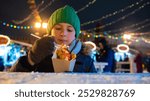 boy, child eats sweet Hong Kong waffles at the Christmas festival, winter market in the city center	