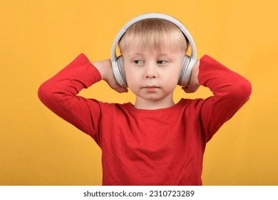 boy child enjoys music in headphones - Shutterstock ID 2310723289