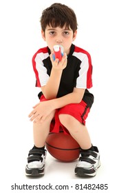 Boy Child With Exercise Or Sport Induced Asthma Attack Sitting On Basketball Over White.