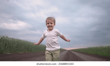 boy child running in nature in park. happy family kid dream concept. free child son runs along a rural road next to a field in nature. free baby runs and lifestyle plays in the park - Powered by Shutterstock