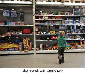 Boy Chooses A Toy Car In The Store