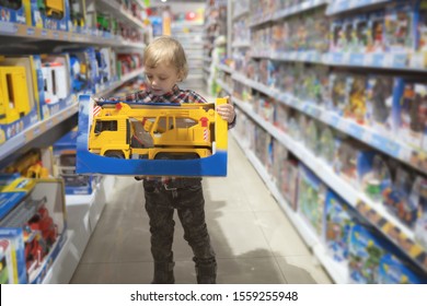 Boy Chooses A Toy Car In The Store