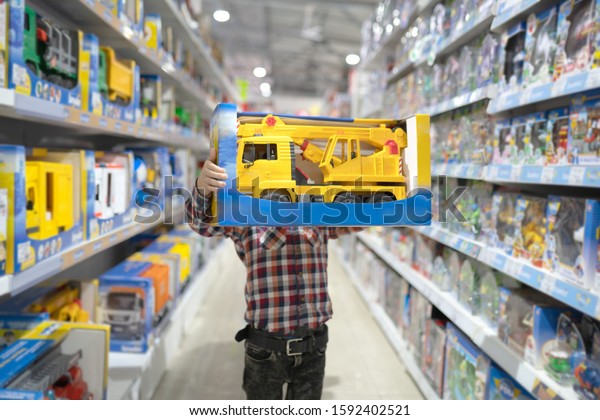 Boy chooses a toy car in\
the store
