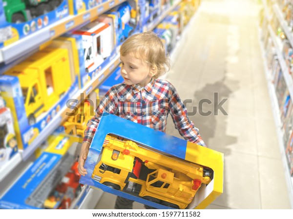 Boy chooses a toy car in
the store
