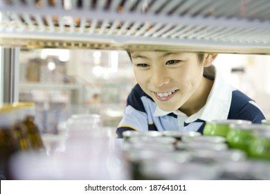 Boy Choosing Drink At Convenience Store