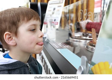 Boy Choosing Ice Cream In Cafe In Park