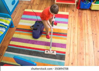 Boy Cleaning  Floor With Hoover
