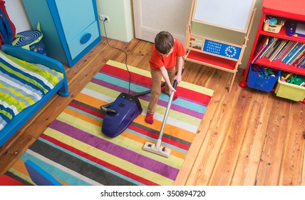 Boy Cleaning  Floor With Hoover
