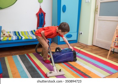 Boy Cleaning  Floor With Hoover
