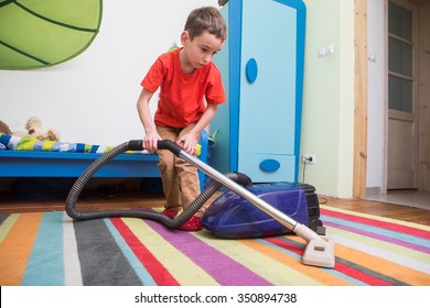 Boy Cleaning  Floor With Hoover
