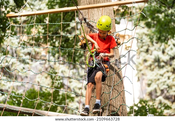 Boy climber walks on\
the rope bridge,