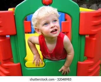 Boy Climbing Through A Hole Whilst Playing Outdoors