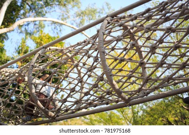 A Boy Climbing Through A Tunnel Of Nets Which Construct By Ropes