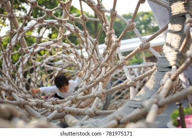 A Boy Climbing Through A Tunnel Of Nets Which Construct By Ropes