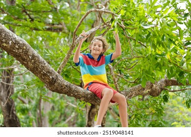 Boy climbing tree in summer park. Kids explore nature. Wild child having fun in forest. Young explorer playing outdoor. Children play and climb trees. Healthy outdoor activity in sunny garden. - Powered by Shutterstock